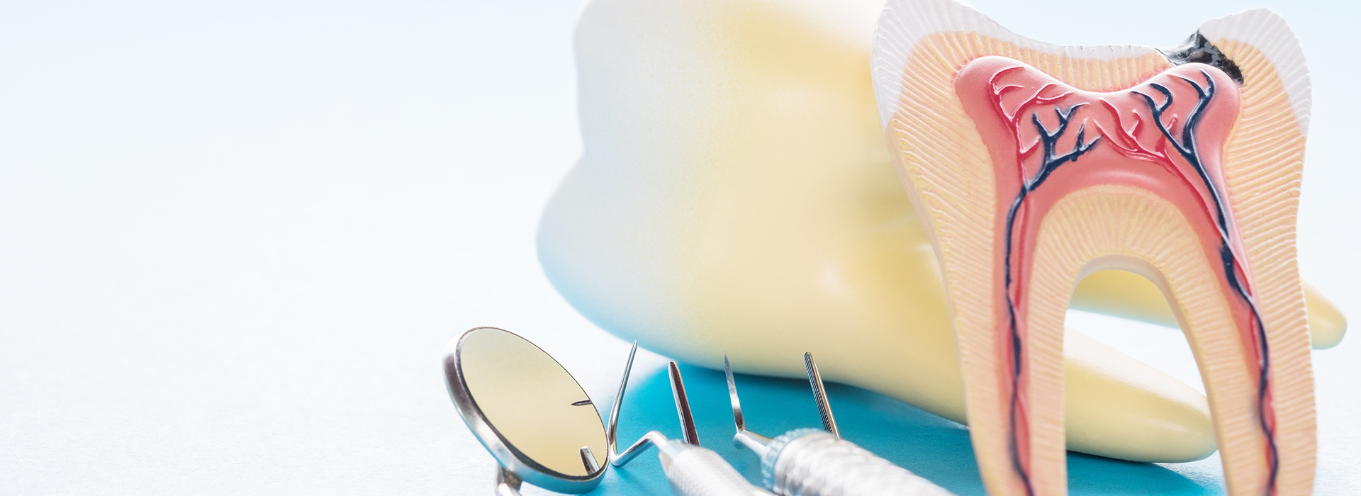 The image shows a pair of yellow teeth with a toothbrush on top, placed against a blue background.