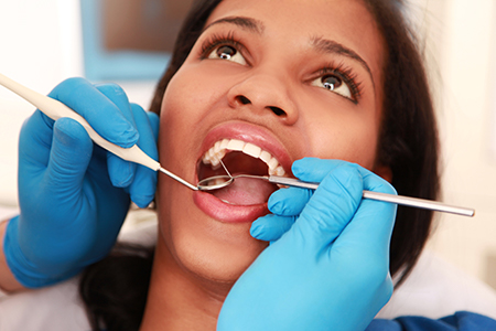 A person receiving dental care with a focus on the dental professional performing the procedure.