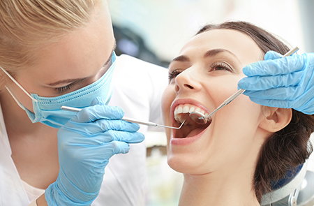 A dental hygienist assisting a patient during a dental cleaning procedure.